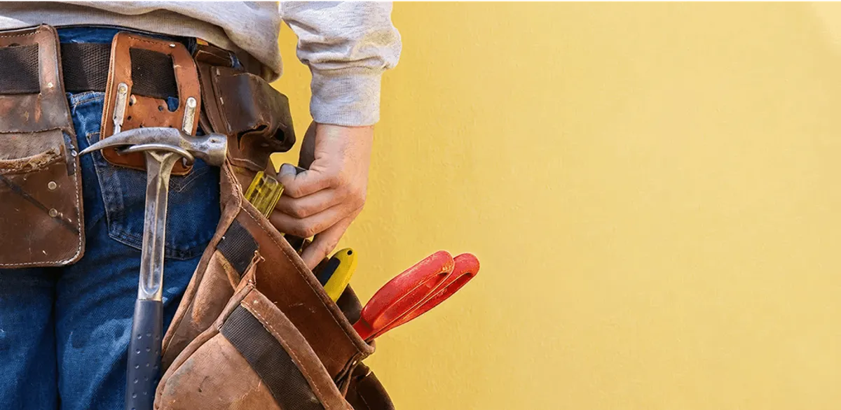 Handyman with tool belt ready for home repairs and maintenance in Raleigh, NC